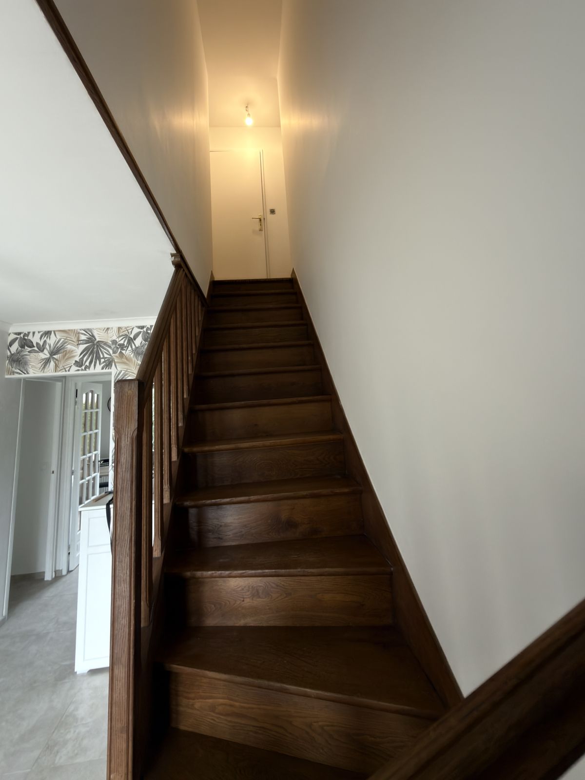 Cage d'escalier après peinture, murs blancs lumineux et escalier bois dégagé - Yvelines