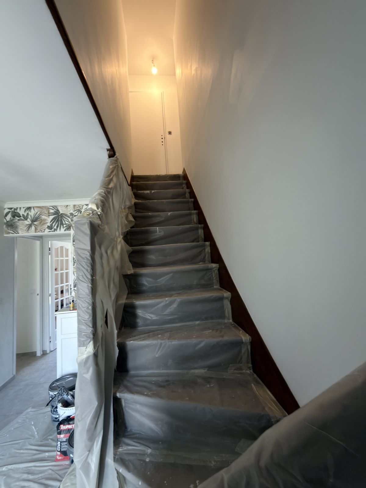 Cage d'escalier pendant le chantier, marches et rampe entièrement bâchées - Yvelines
