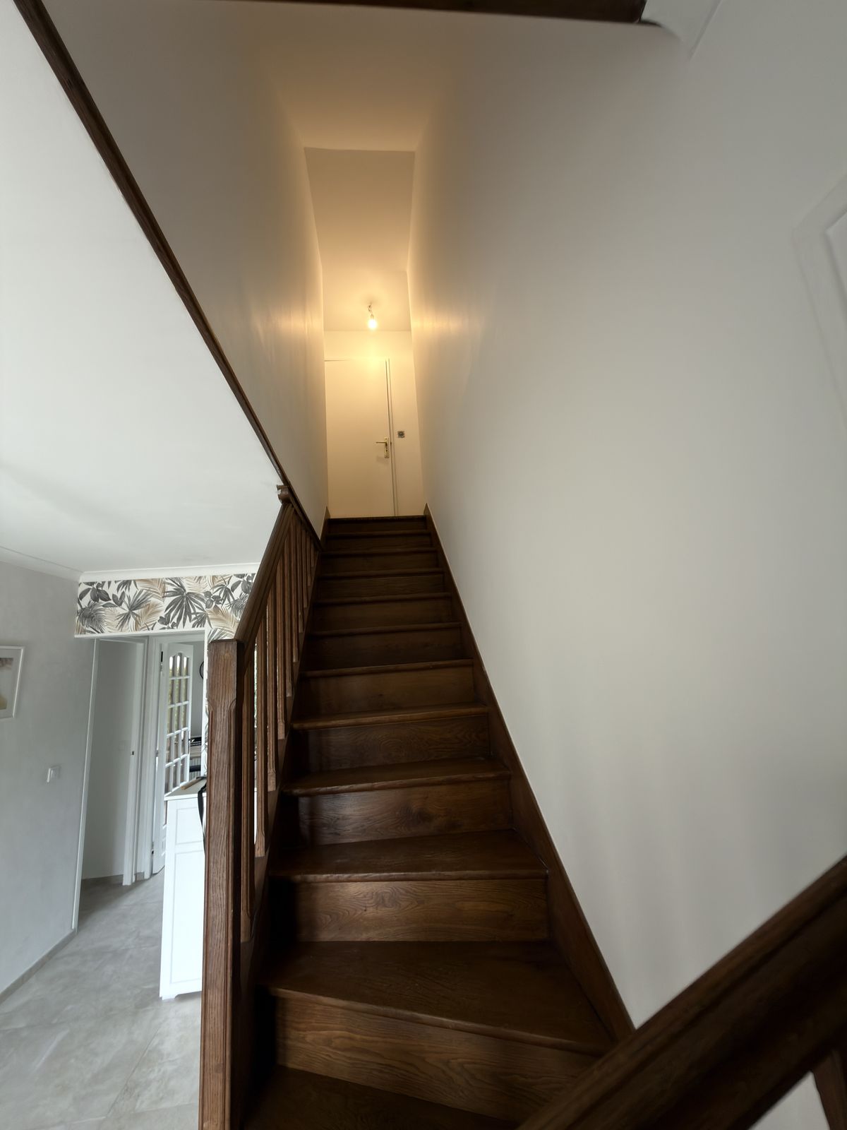 Cage d'escalier repeinte en blanc, escalier bois et rampe préservés (septembre 2026)