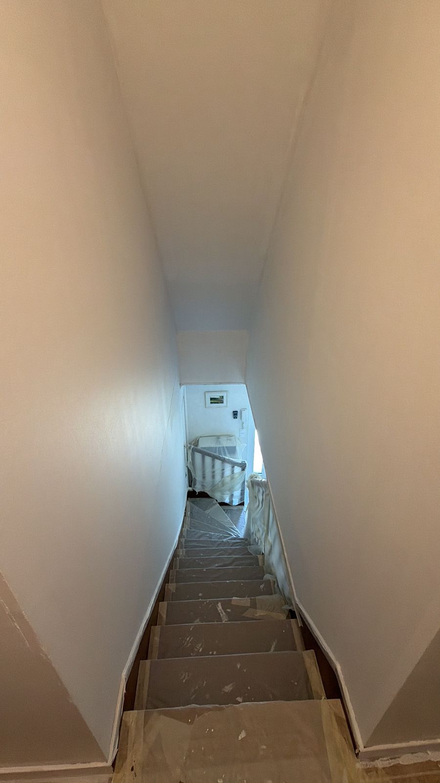 Montée d'escalier vue du palier pendant le chantier, marches bâchées - Yvelines
