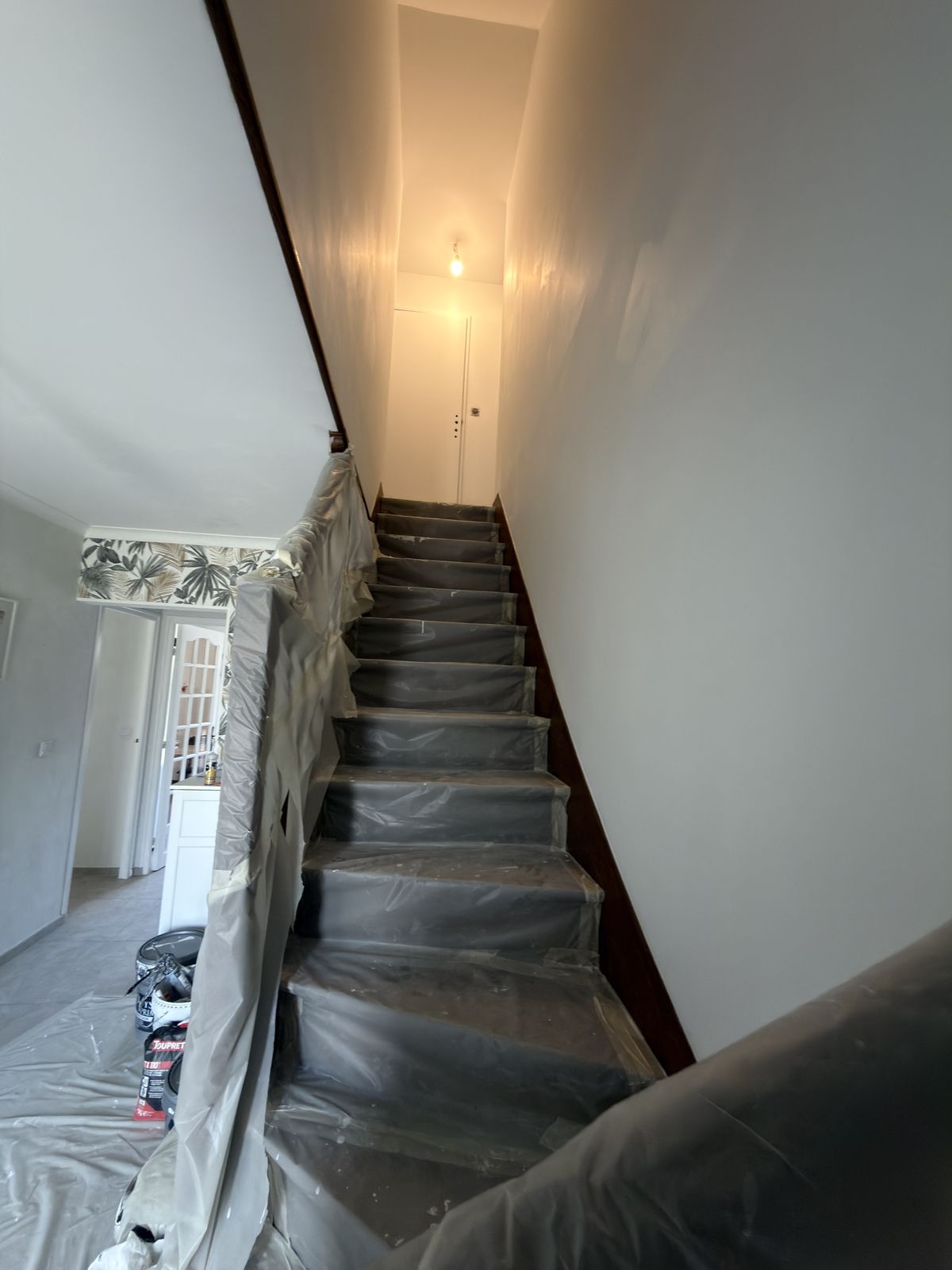 Escalier et rampe entièrement bâchés avant peinture de la cage d'escalier - chantier Yvelines