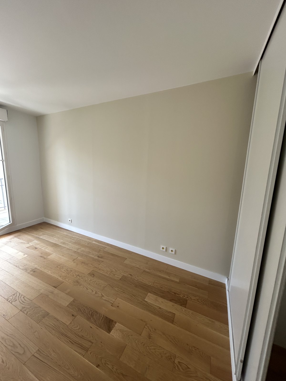 Chambre repeinte en beige grège, parquet chêne clair et placard coulissant blanc - Yvelines