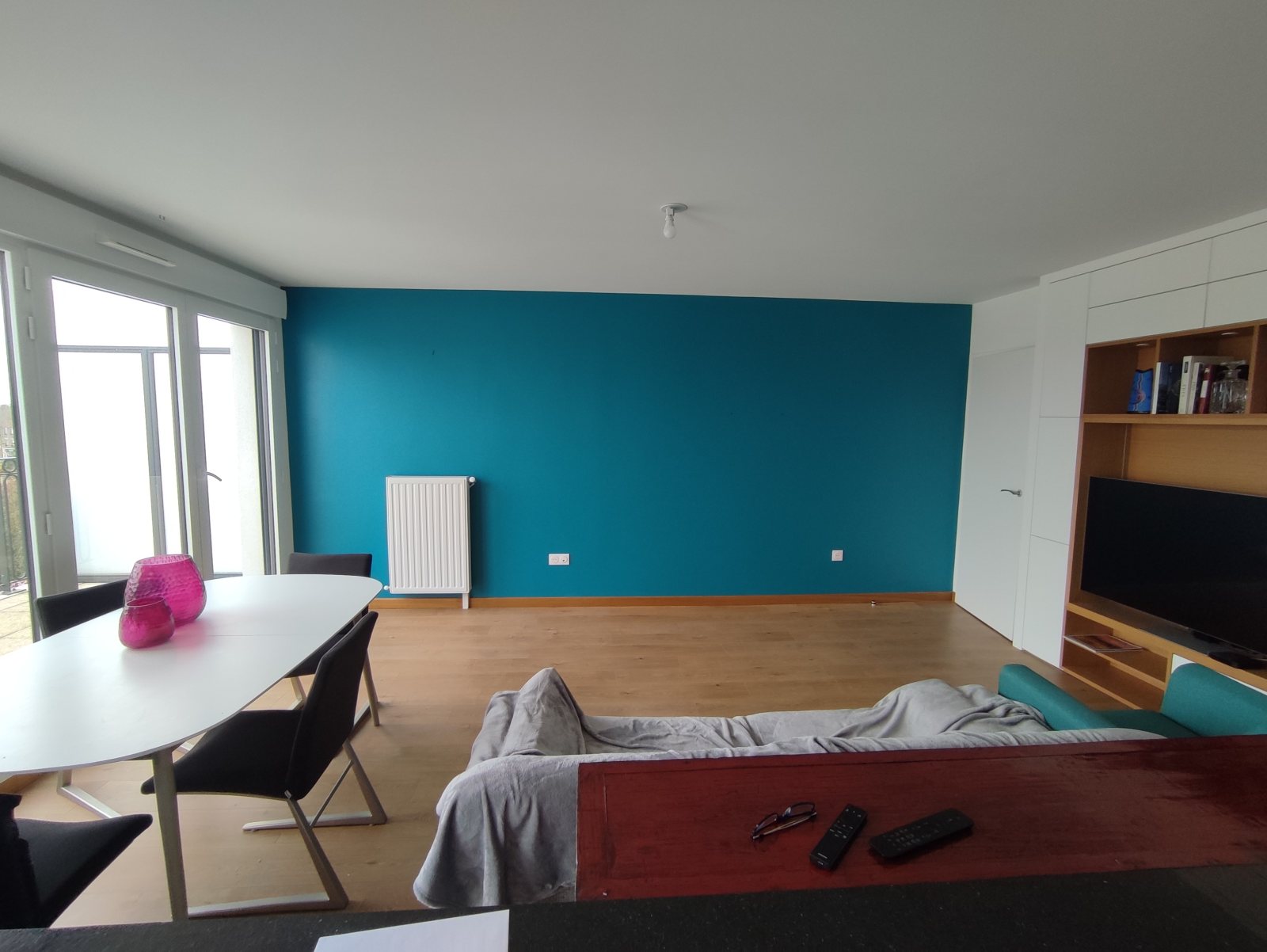 Salon avec mur d'accent bleu canard : peinture intérieure et parquet préservé
